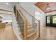 Bright staircase with wooden steps, black railings, and oak ceiling at 3601 Woody Grove Ln, Charlotte, NC 28210