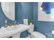 Stylish bathroom features a pedestal sink, round mirror, and elegant fixtures in a modern design at 5060 Harrowsmith Ln, Charlotte, NC 28204