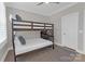 The well-lit bedroom features bunk beds, wood floors, and a ceiling fan for comfort and style at 5060 Harrowsmith Ln, Charlotte, NC 28204