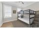 Cozy bedroom offers a bunk bed, wood flooring, and a bright window for a cheerful space at 5060 Harrowsmith Ln, Charlotte, NC 28204