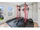 Bright exercise room with gym equipment and weights on a black padded floor at 5060 Harrowsmith Ln, Charlotte, NC 28204