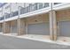 Three car garage with brick facade and gray doors at 5060 Harrowsmith Ln, Charlotte, NC 28204