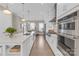 Modern kitchen with stainless steel appliances, island with seating, and stylish lighting at 5060 Harrowsmith Ln, Charlotte, NC 28204