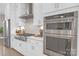 Close-up of a modern kitchen featuring stainless steel appliances and white cabinetry at 5060 Harrowsmith Ln, Charlotte, NC 28204