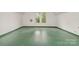 Spacious attic with green painted floorboards and natural light from two large windows at 520 Eastwood Park Cir, Albemarle, NC 28001