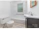 Bathroom featuring a sink, toilet, tub and window with a shower at 520 Eastwood Park Cir, Albemarle, NC 28001