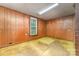Bedroom featuring wood paneled walls, a window with natural light, and worn floors at 520 Eastwood Park Cir, Albemarle, NC 28001