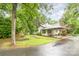 Charming home exterior with a lush lawn, mature trees, and a covered driveway at 520 Eastwood Park Cir, Albemarle, NC 28001