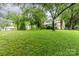 Expansive lawn with mature trees surrounding the home's exterior at 520 Eastwood Park Cir, Albemarle, NC 28001