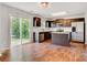 Kitchen features stainless steel appliances, central island and dark wood cabinets with view to exterior at 5311 Oakdale Ridge Rd, Charlotte, NC 28216
