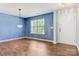 Living room with new flooring, modern chandelier, and a bright window with great natural light at 5311 Oakdale Ridge Rd, Charlotte, NC 28216