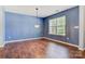 Living room with new flooring, modern chandelier, and a bright window letting in natural light at 5311 Oakdale Ridge Rd, Charlotte, NC 28216