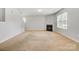 Cozy living room featuring a fireplace, neutral carpet, and large window for natural light at 5311 Oakdale Ridge Rd, Charlotte, NC 28216