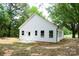 Back of the house with white siding, well-maintained lawn, and small patio area perfect for relaxing outdoors at 617 English St, Monroe, NC 28110