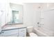 Well-lit, clean bathroom featuring a shower-tub combination and a large vanity with quartz countertop at 617 English St, Monroe, NC 28110