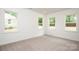 Bright bedroom with three windows, plush carpeting, and neutral paint throughout at 617 English St, Monroe, NC 28110