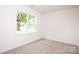 Bright bedroom features neutral carpet, fresh white walls, and a large window offering plenty of natural light at 617 English St, Monroe, NC 28110