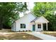 Charming, newly renovated one-story home features a bright blue door and pristine white siding at 617 English St, Monroe, NC 28110