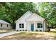 Charming home with light colored siding, a well-manicured lawn, a small porch, and a vibrant blue front door at 617 English St, Monroe, NC 28110