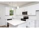 Modern kitchen with bright white cabinets, stainless steel appliances, quartz countertops and a central island at 617 English St, Monroe, NC 28110