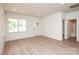 Bright living area with modern wood-look floors, white walls, and recessed lighting leading to a bathroom and bedroom at 617 English St, Monroe, NC 28110