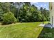 Lush backyard featuring a grass lawn and patio area, adjacent to a vibrant wooded area at 6229 Sid Crane Dr, Charlotte, NC 28216