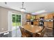 Bright kitchen featuring wooden cabinetry, black appliances, and an adjacent dining area at 6229 Sid Crane Dr, Charlotte, NC 28216