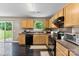 Well-lit kitchen featuring wooden cabinets, black appliances, and an eye-catching backsplash at 6229 Sid Crane Dr, Charlotte, NC 28216