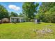 Expansive backyard with lush green lawn, mature trees, providing ample space for outdoor activities at 6718 Pueblo Ln, Charlotte, NC 28227