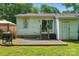 View of back of the house with backyard featuring a small patio area with grill and partially fenced yard at 6718 Pueblo Ln, Charlotte, NC 28227
