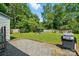 Outdoor space featuring a patio, large yard, grilling area, and mature trees, perfect for relaxation and entertainment at 6718 Pueblo Ln, Charlotte, NC 28227