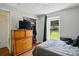 A neat bedroom with a dresser, a window view to the backyard, and a queen sized bed at 6718 Pueblo Ln, Charlotte, NC 28227