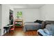 A bedroom with wood floors, a window, a crib, a recliner, and a desk at 6718 Pueblo Ln, Charlotte, NC 28227