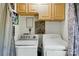 An efficiently designed laundry room featuring a washer, dryer, and overhead storage cabinets at 6718 Pueblo Ln, Charlotte, NC 28227