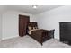 This bedroom is carpeted with a dark wood bed and earth-toned bedding at 679 Cape Fear St, Fort Mill, SC 29715