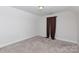 A well-lit bedroom features neutral walls and carpet, with a window dressed in dark brown curtains at 679 Cape Fear St, Fort Mill, SC 29715