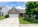 Charming single-story home boasts a stone-accented facade, attached two-car garage, and lush green lawn at 679 Cape Fear St, Fort Mill, SC 29715