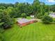 Overhead view of a brick home with a large lawn, showcasing its setting among mature trees at 6900 Ridge Lane Rd, Charlotte, NC 28262