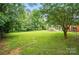 Landscaped backyard with mature trees and expansive lawn at 6900 Ridge Lane Rd, Charlotte, NC 28262