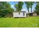 View of two backyard sheds with lots of green grass and mature trees on a sunny day at 6900 Ridge Lane Rd, Charlotte, NC 28262