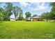 Extensive backyard showing a lawn with mature trees surrounding the back of the house at 6900 Ridge Lane Rd, Charlotte, NC 28262