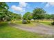 Circular driveway with flowering bushes leading to a charming home surrounded by mature trees at 6900 Ridge Lane Rd, Charlotte, NC 28262