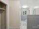 Hallway leading to a bathroom with gray tile and white fixtures at 6900 Ridge Lane Rd, Charlotte, NC 28262