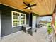 Covered porch features a wooded ceiling, grey furniture, and large backyard at 7133 Church Rd, Taylorsville, NC 28681