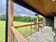 Covered back porch with wooded ceiling, metal railing and view of the expansive backyard at 7133 Church Rd, Taylorsville, NC 28681