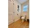 Clean and modern half-bathroom with a toilet, window, and minimalist decor at 7133 Church Rd, Taylorsville, NC 28681