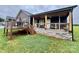 Home's exterior featuring a stone foundation and a covered back porch with wooded ceiling at 7133 Church Rd, Taylorsville, NC 28681
