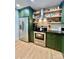 Updated kitchen with stainless steel appliances, green cabinets, and open shelving above the stove at 7133 Church Rd, Taylorsville, NC 28681