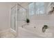 Bright bathroom featuring a shower, and a soaking tub under a window at 727 Torrey Pines Ln, Fort Mill, SC 29715