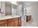 Bathroom featuring double vanities, a large mirror, and a doorway to the commode and shower area at 727 Torrey Pines Ln, Fort Mill, SC 29715